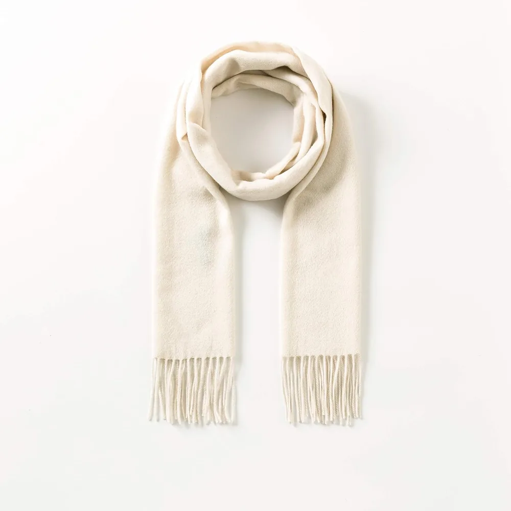 Ivory cashmere scarf laid flat, fringe on both ends
